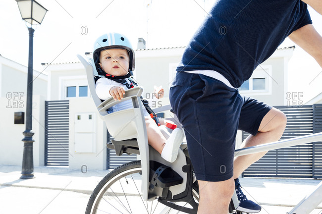 Father with son sitting in safety seat of bicycle
