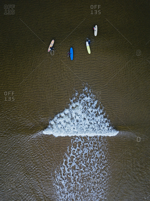 Aerial view of people surfing in brown waters of Barents Sea