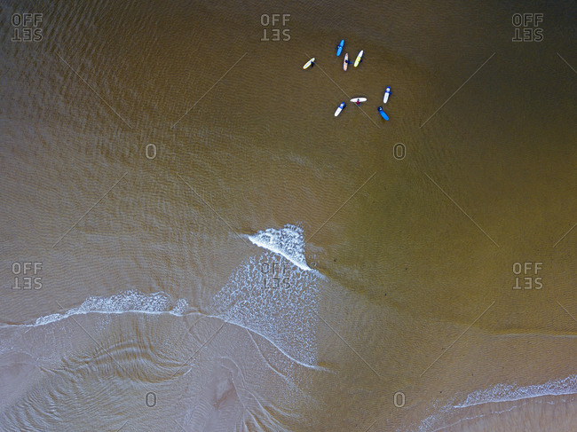Aerial view of people surfing in brown waters of Barents Sea