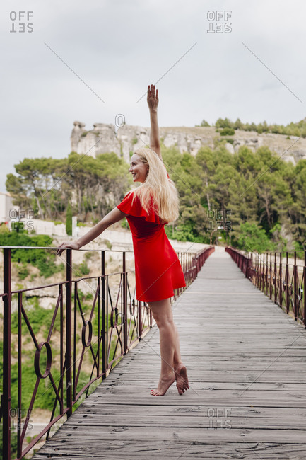Ballerina wearing red dress on Saint Paul Bridge in Cuenca- Spain