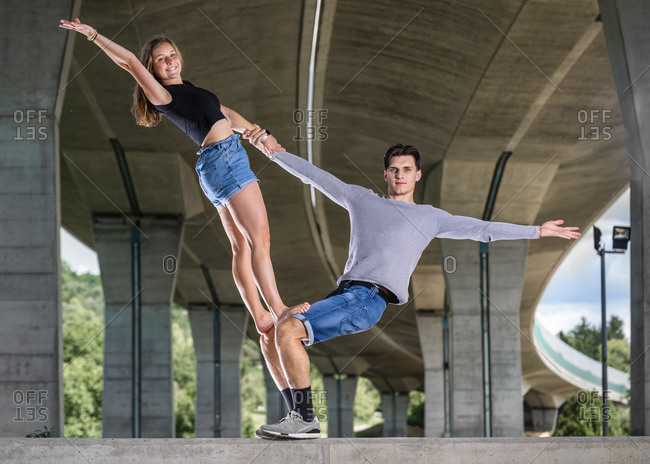 Young couple doing acrobatics outdoors