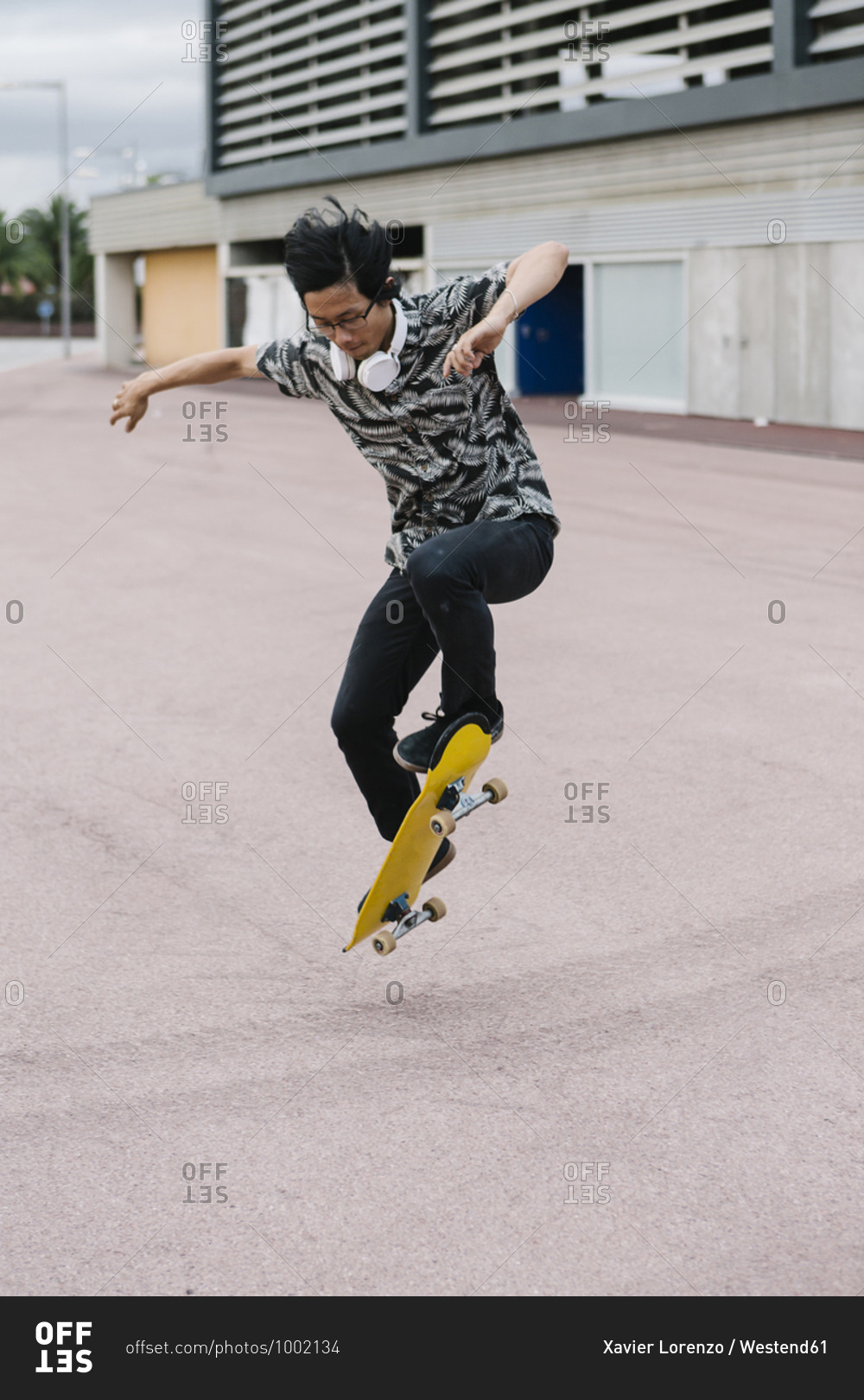 Young man jumping while skateboarding on street in city