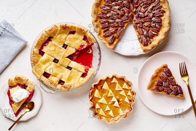 Top view shot of variety of thanksgiving pies: berry pie, pumpkin pie and pecan tart