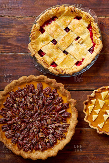 Variety of thanksgiving pies on wooden table.