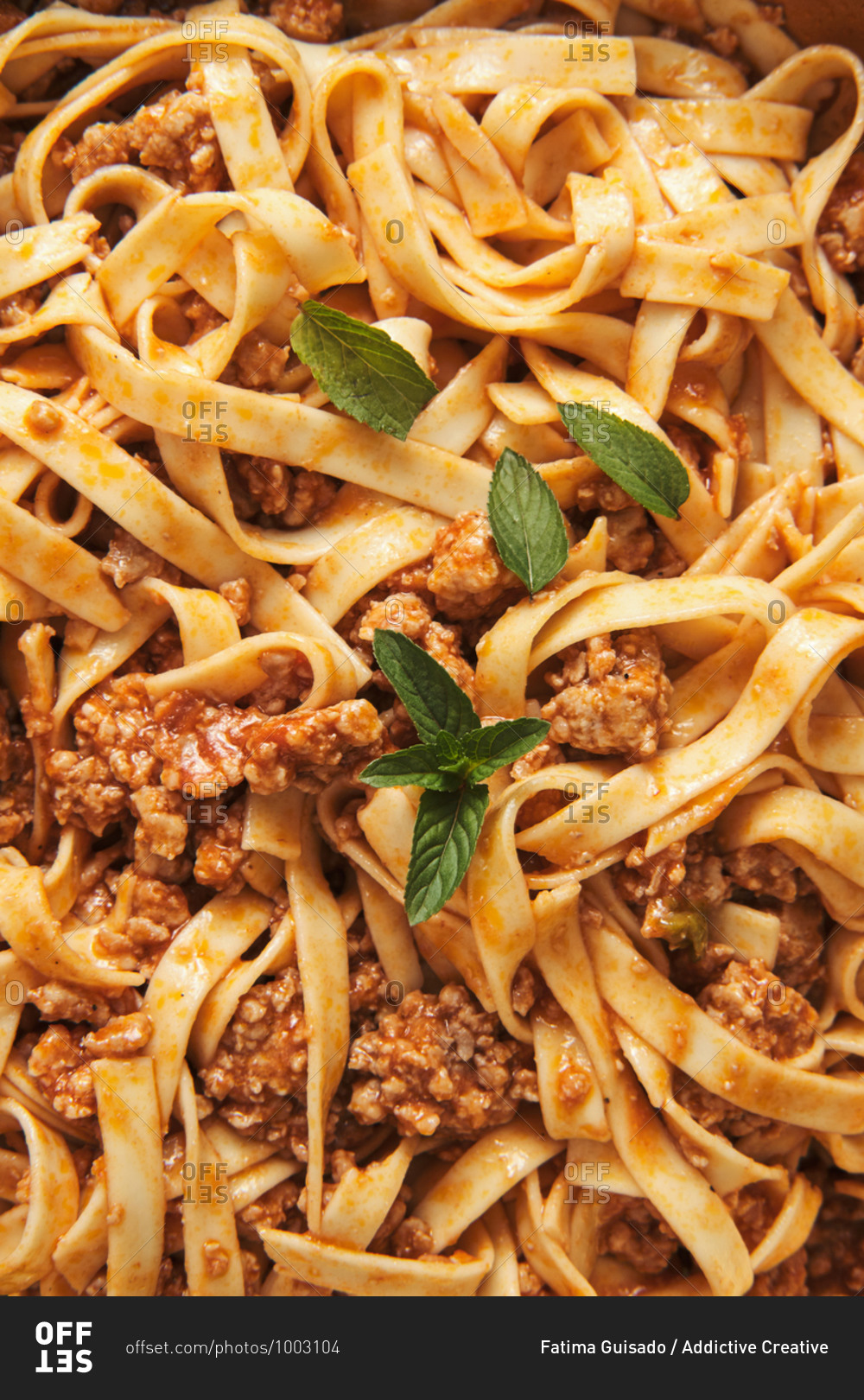 Closeup top view of appetizing homemade pasta with Bolognese sauce served with fresh basil leaves