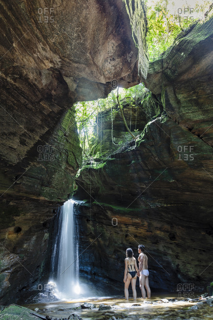 March 10, 2019: Backpackers enjoying a pristine waterfall and mountain stream in the heart of the South American rainforest, Minas Gerais, Brazil, South America