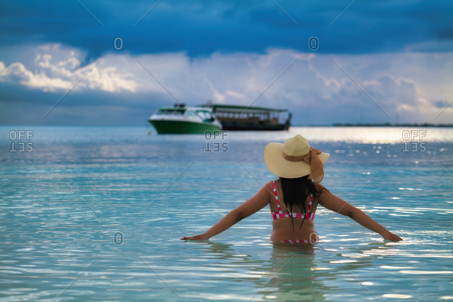 A female tourist in the blue waters of The Maldives, Indian Ocean, Asia