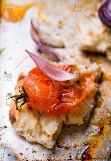 Toasted bread with crushed baked tomato on metal baking tray