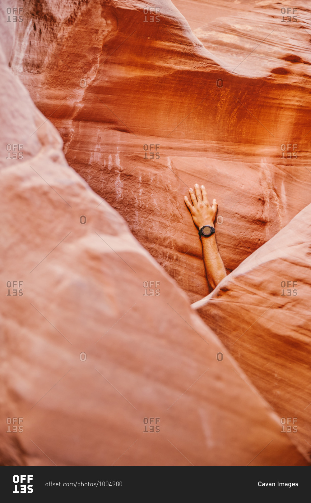 Hand with fitness watch against slot canyon wall in Escalante, Utah.