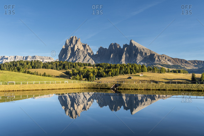 Alpe di Siusi, Castelrotto, South Tyrol, Bolzano province, Italy, Europe. The Sassolungo massif is reflected in a lake on the Alpe di Siusi
