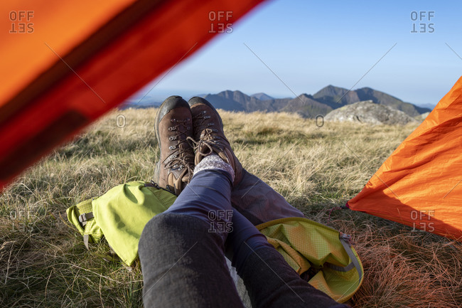 Wild camping on the summit of Glyer Fach in Snowdonia with a view of Snowdon from the tent