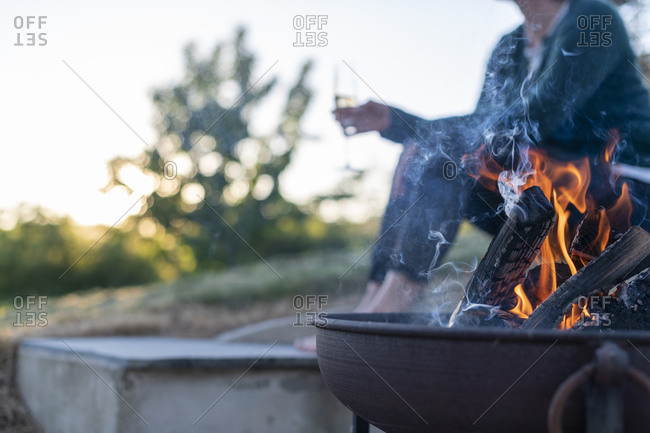 Metal tea kettle heating up over a campfire stock photo - OFFSET