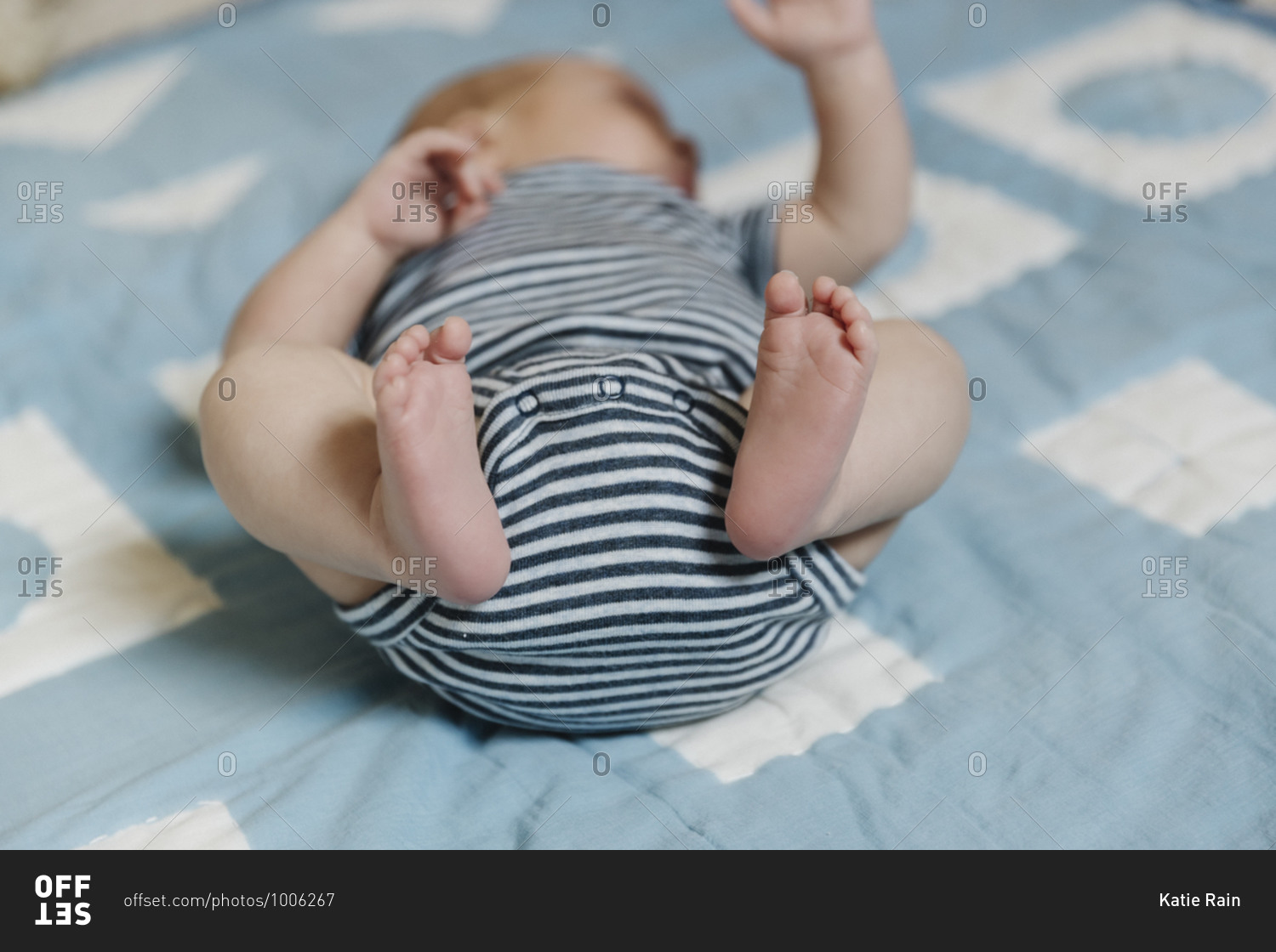 Close up a baby\'s feet lying on a blue blanket