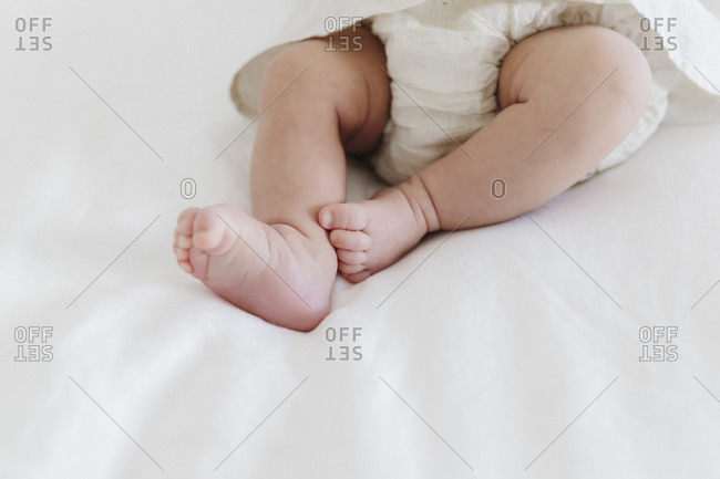 Little baby feet on white sheets
