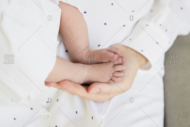 Parent holding newborn baby's foot in in hands