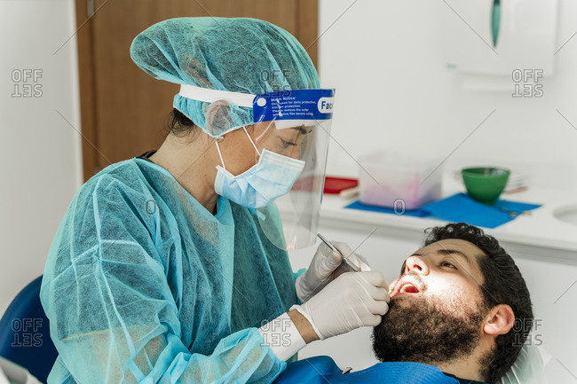 Female nurse examining male patient in dentist's clinic