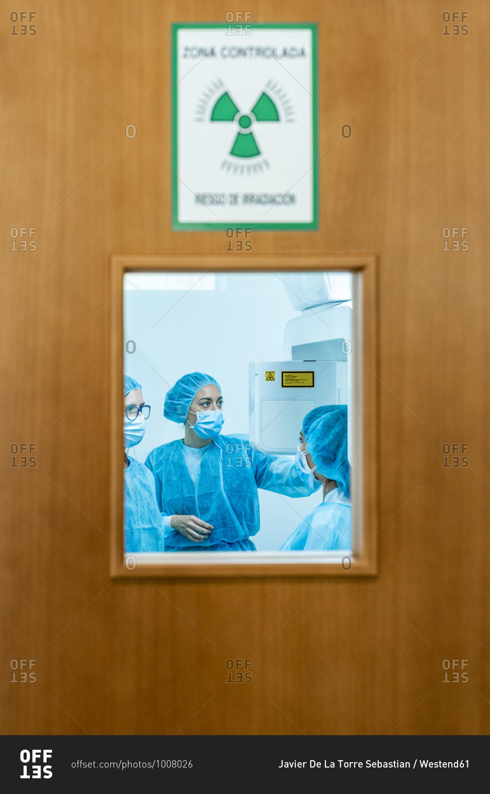 Doctor talking to nurses in dentist\'s clinic behind door