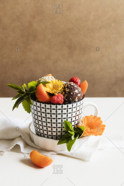 Dessert with energy balls (raw confectionery) and fresh fruits and flowers