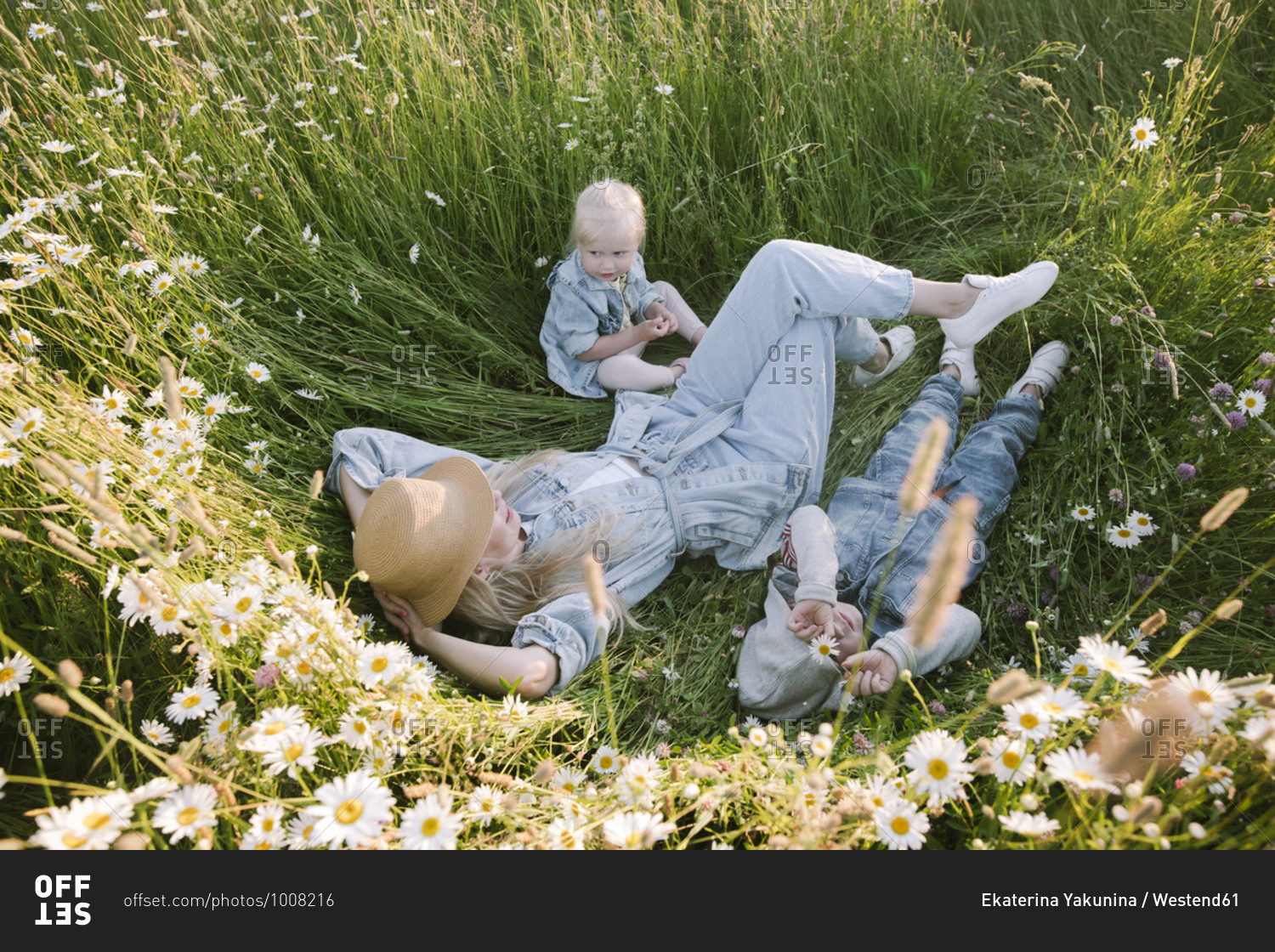 Mother with daughter and son lying on flower field