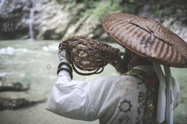European yamabushi monk in traditional shugendo robe blowing the horagai conch horn