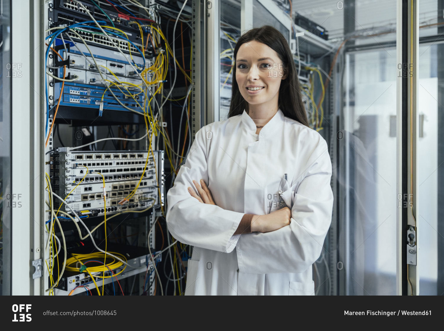 Young woman with arms crossed standing in data center