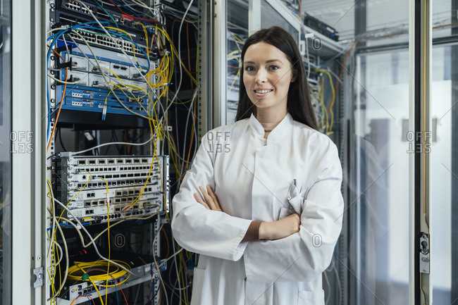 Young woman with arms crossed standing in data center