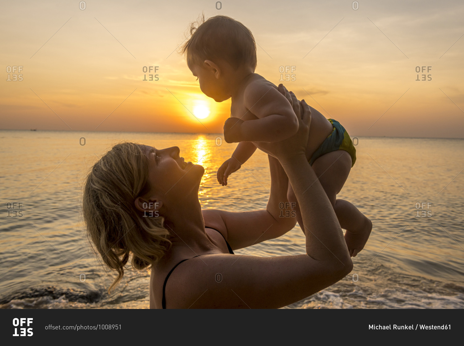 Vietnam- Phu Quoc island- Ong Lang beach- Mother holding baby in beach at sunset