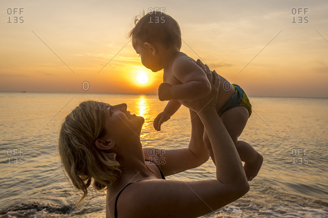 Vietnam- Phu Quoc island- Ong Lang beach- Mother holding baby in beach at sunset