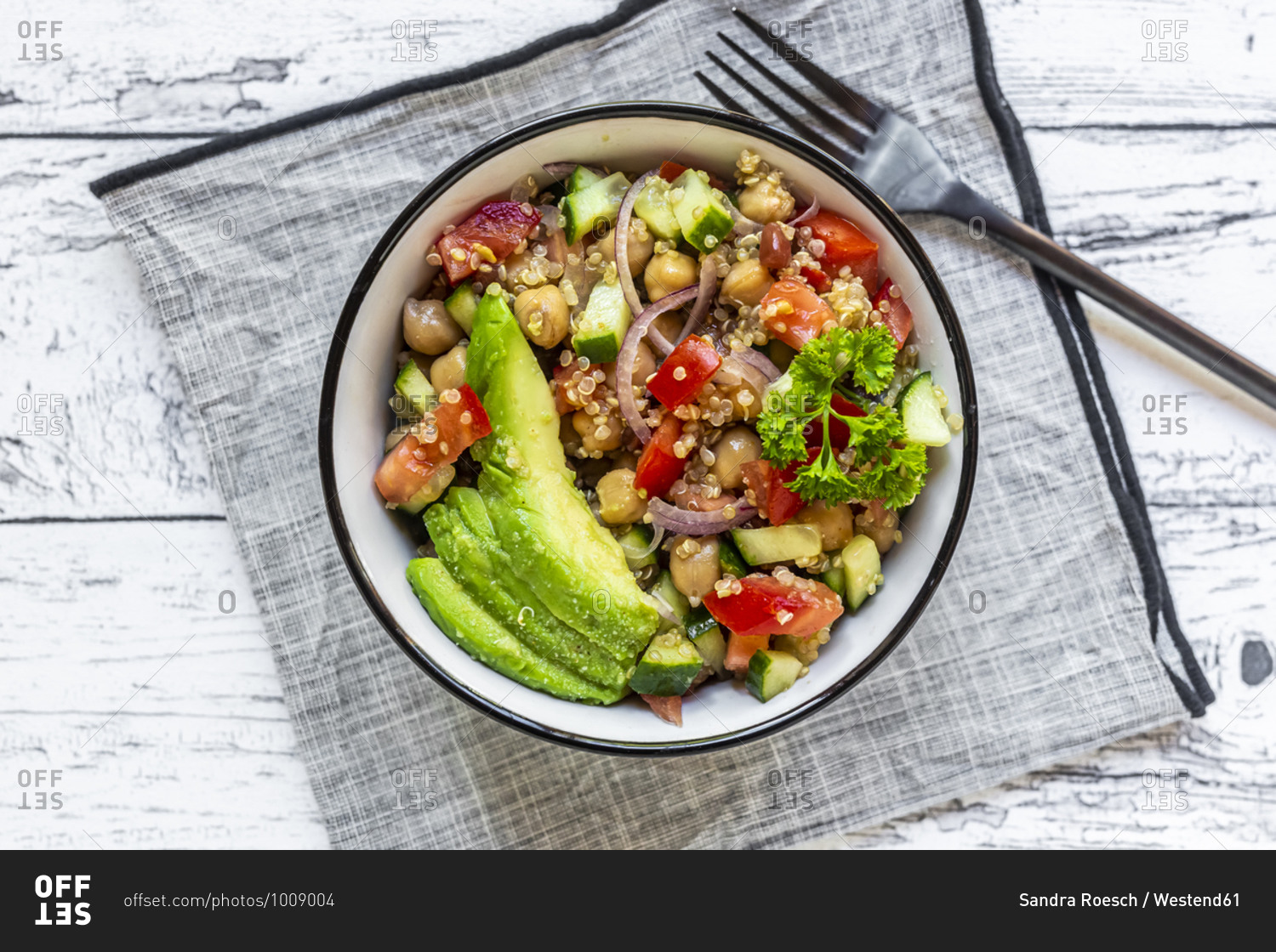 Bowl of vegetarian quinoa salad with chick-peas- avocado- cucumber- tomato- onion and parsley