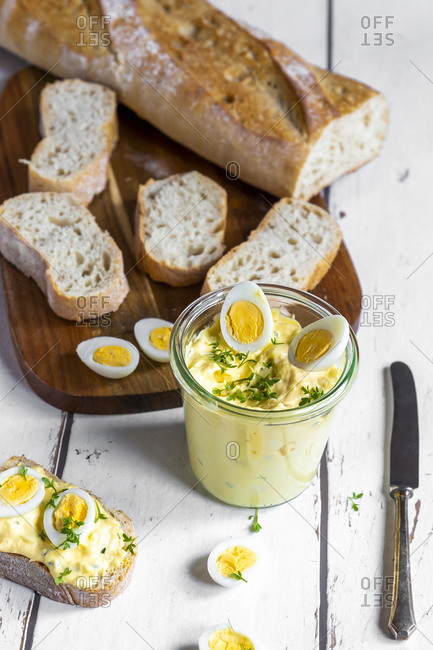 Sliced baguette and jar of homemade egg salad with cress