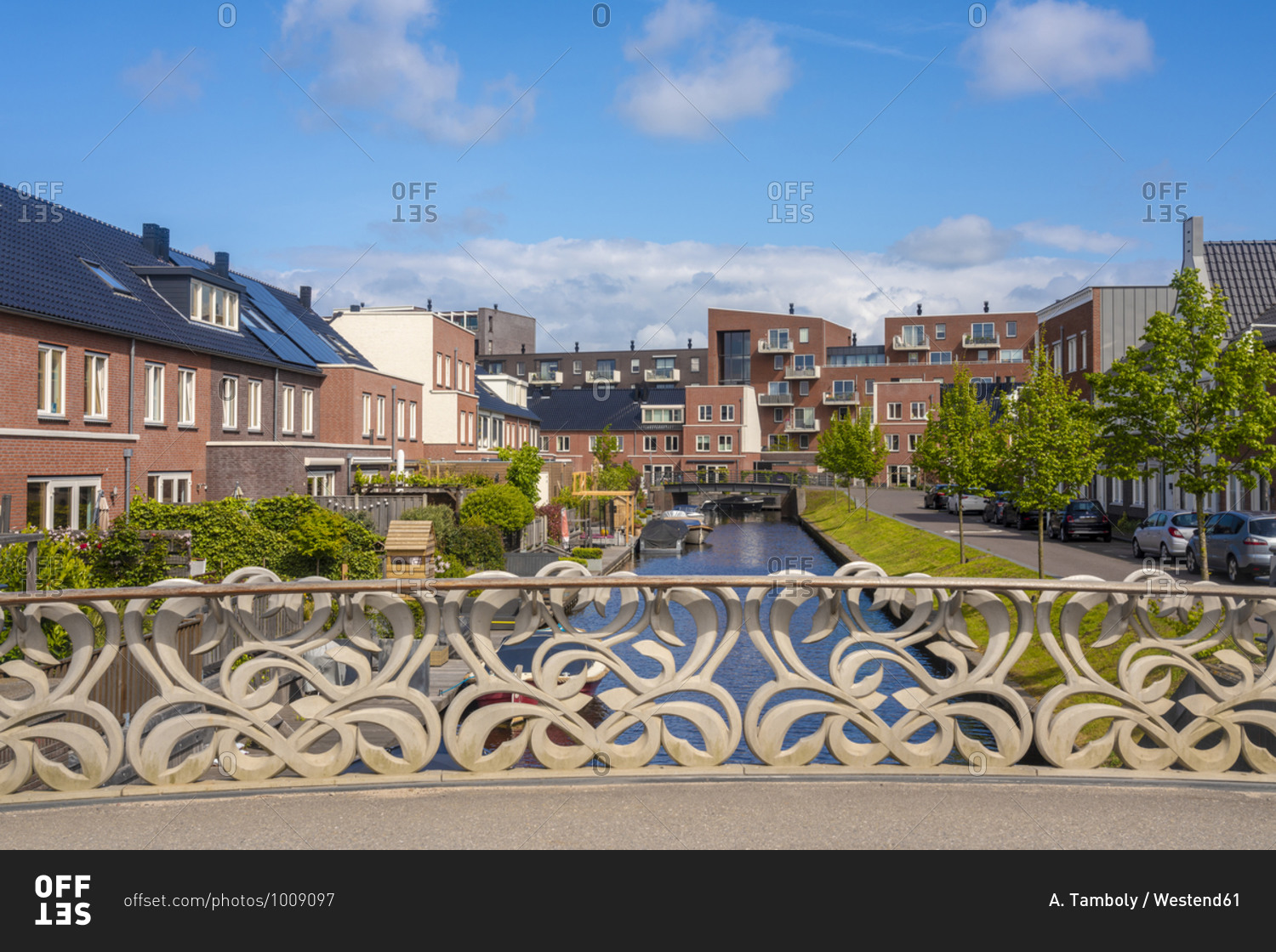 Netherlands- South Holland- Oegstgeest- Railing of bridge stretching over city canal with houses in background