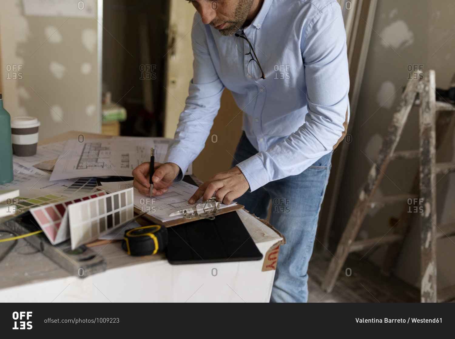 Architect at work with construction plan and color swatch