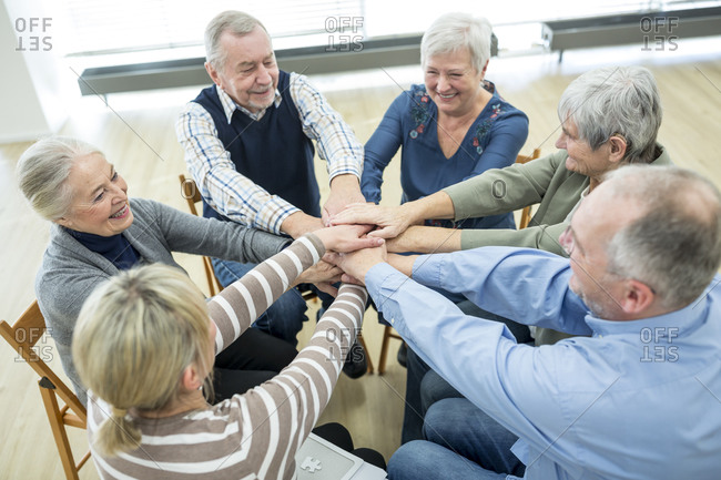 Group of active seniors stacking hands- symbolizing solidarity