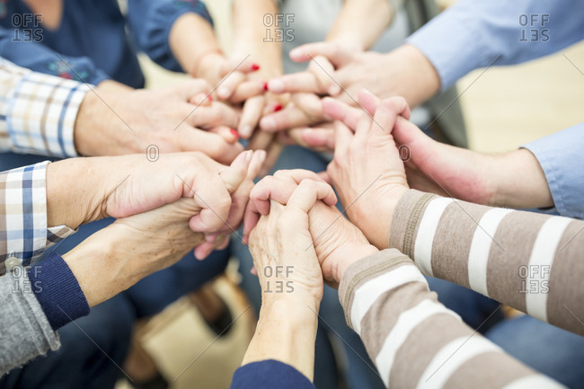 Close up of seniors- stacking hands- symbolizing solidarity