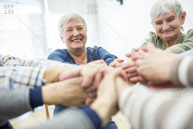 Group of active seniors stacking hands- symbolizing solidarity