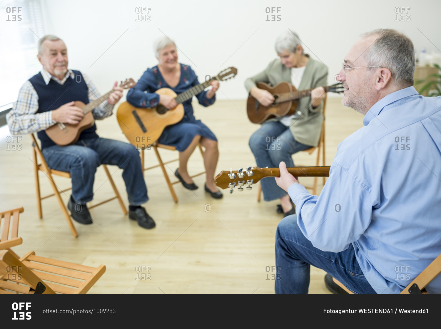 Seniors in retirement home attending guitar class- making music