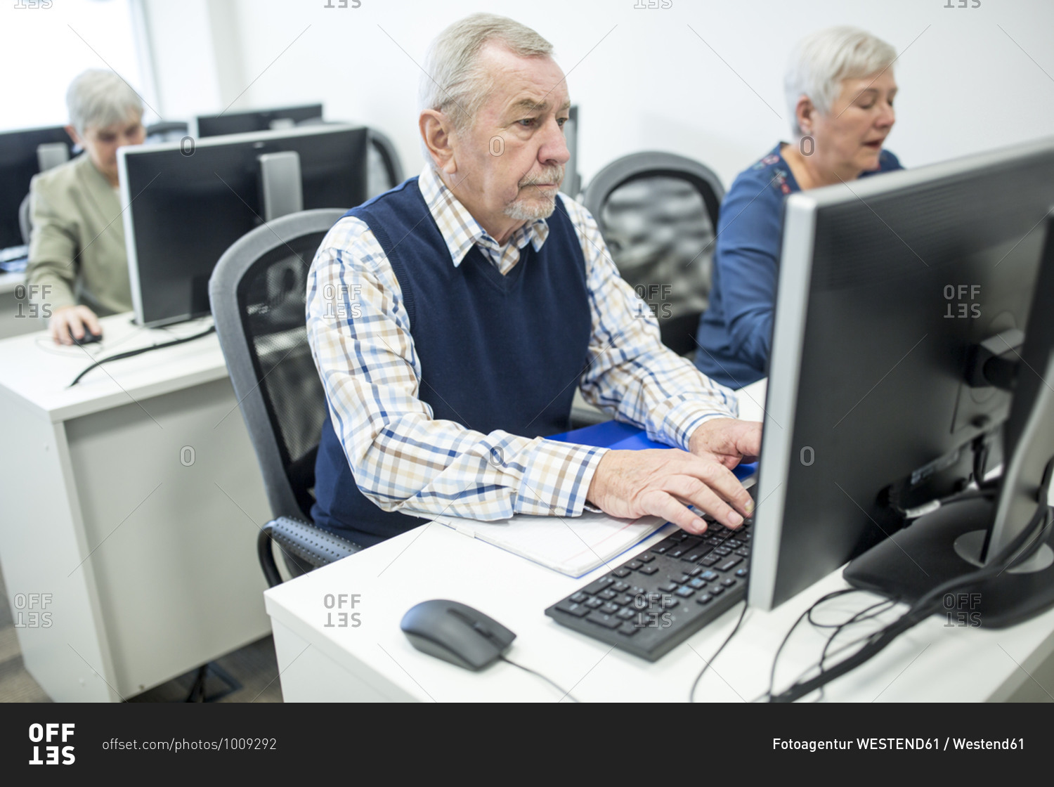 Active seniors attending computer course- working on PC