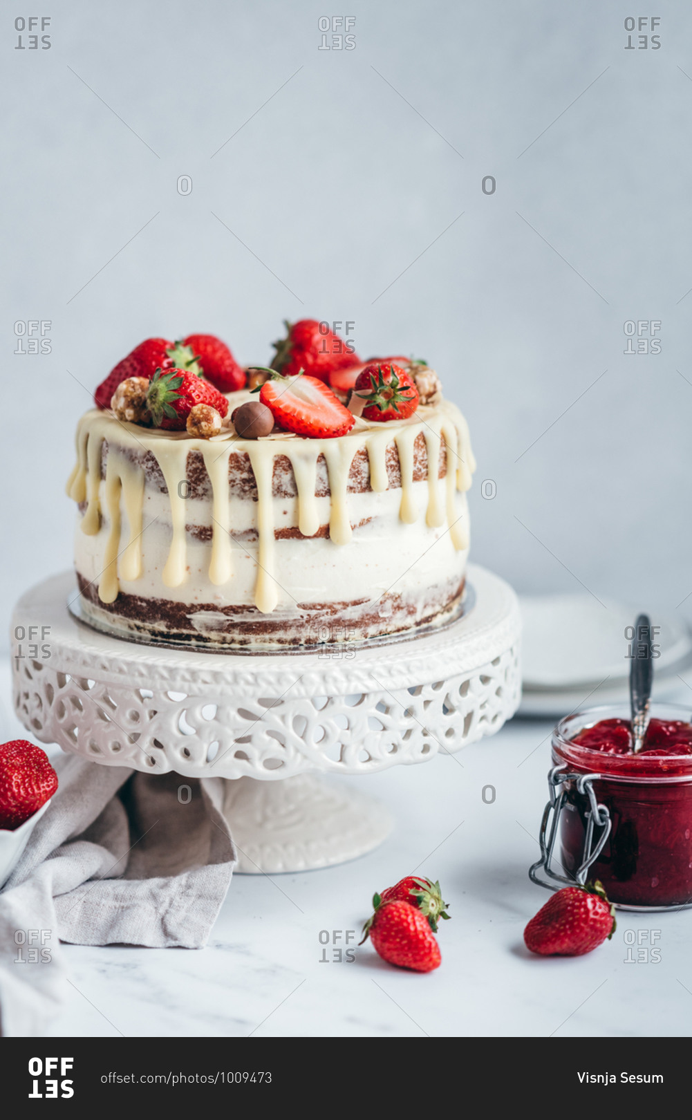 Cake with strawberries and strawberry jam on the table