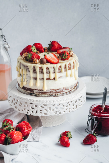 Strawberry cake, strawberries and strawberry jam on white table