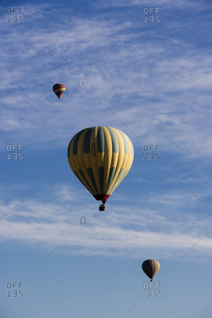 Three hot air balloons floating against blue sky, Goreme National Park, Cappadocia, Anatolia, Turkey