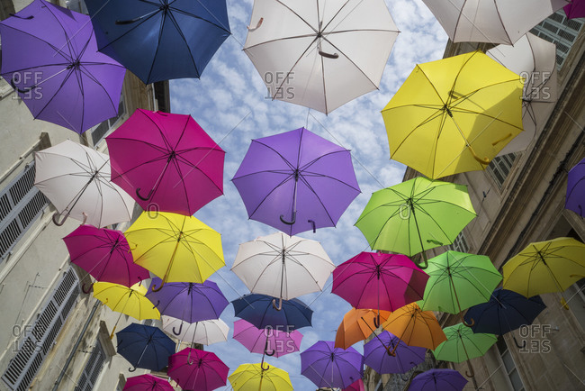 Art installation with colourful umbrellas in a street in Arles, Provence, France