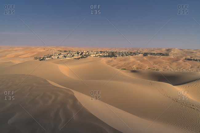 Distant view of Qsar Al Sarab desert resort among sand dunes, Empty Quarter Desert, Abu Dhabi, United Arab Emirate