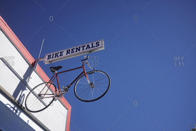 Bicycle sign for bike rental against blue sky, California, USA