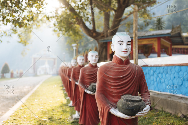 Row of buddhist monk statues holding ban bats, Kaw Ka Thawng Cave, Hpa An, Kayin State, Myanmar