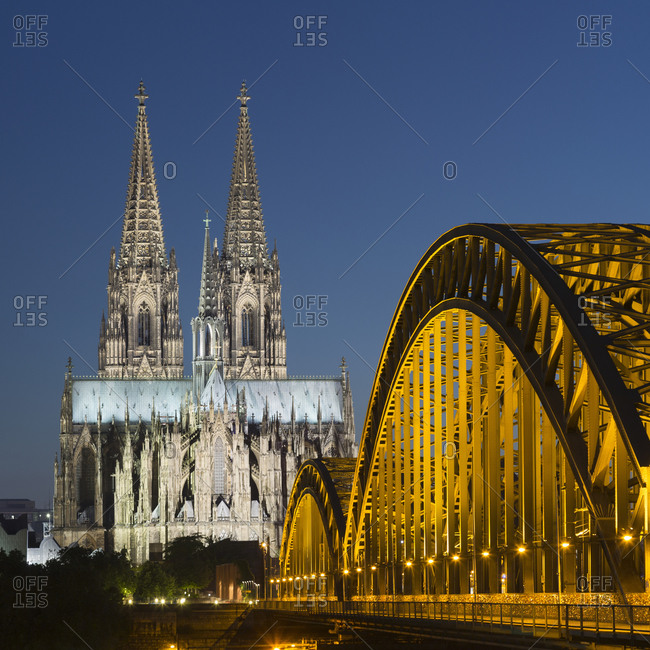 Hohenzollern Bridge (Hohenzollernbruecke) and Cologne Cathedral (Koelner Dom) spires at night, Cologne, Germany