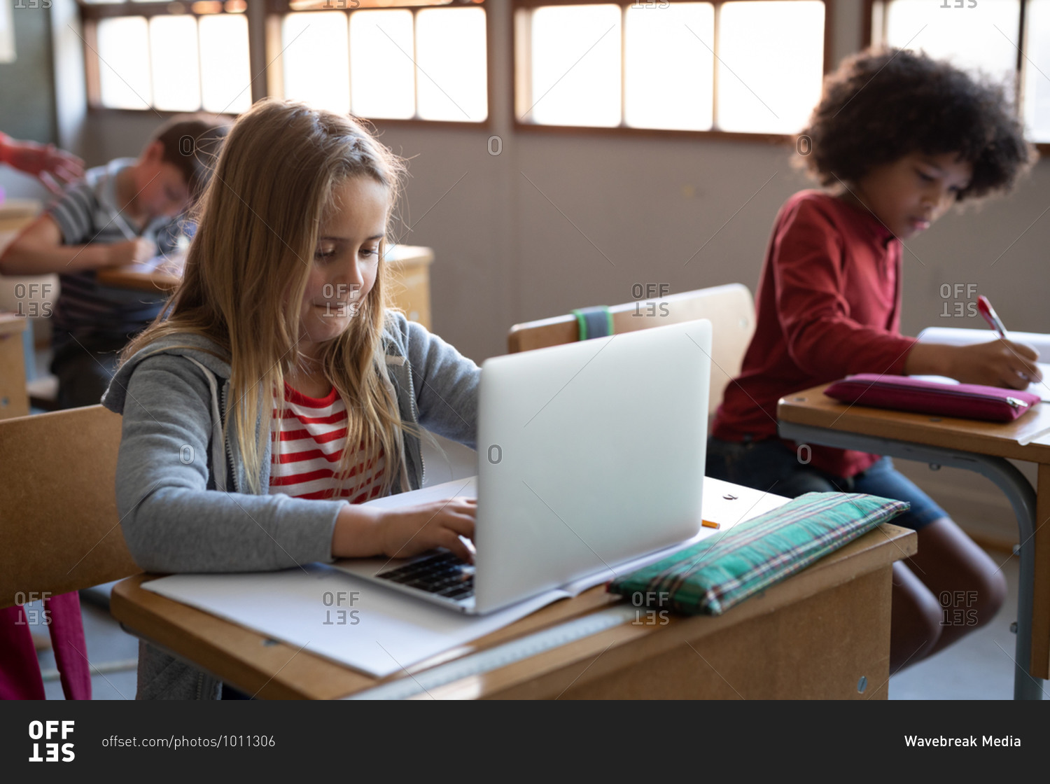 Caucasian girl using laptop during the lesson. Primary education social distancing health safety during Covid19 Coronavirus pandemic.