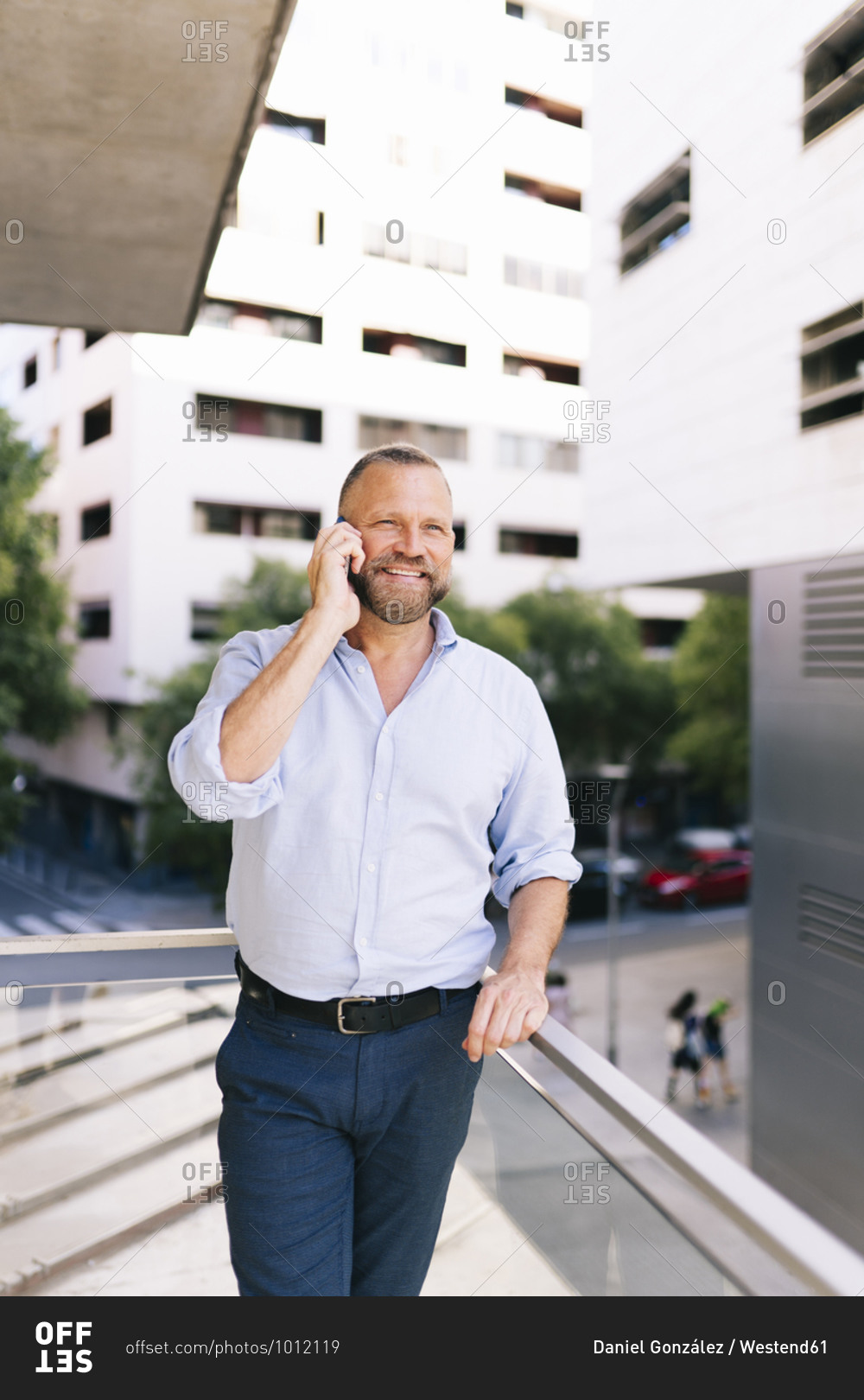 Businessman talking on mobile phone while standing in balcony of office