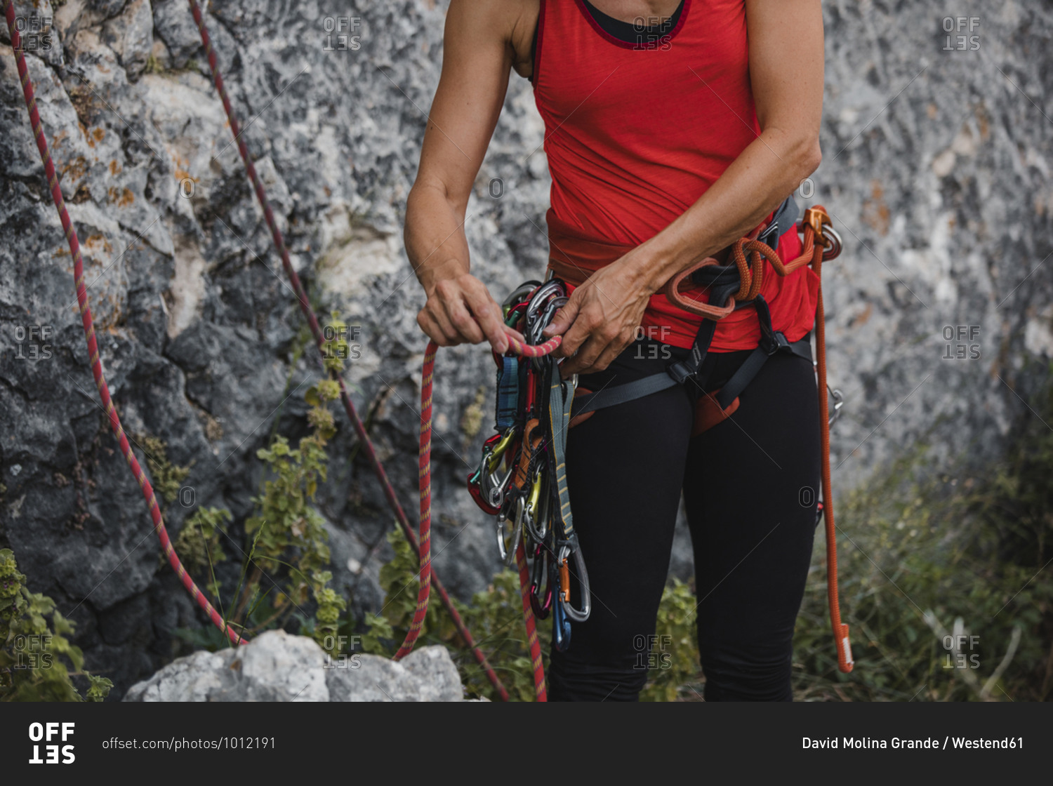 Woman adjusting ropes while preparing for rock climbing