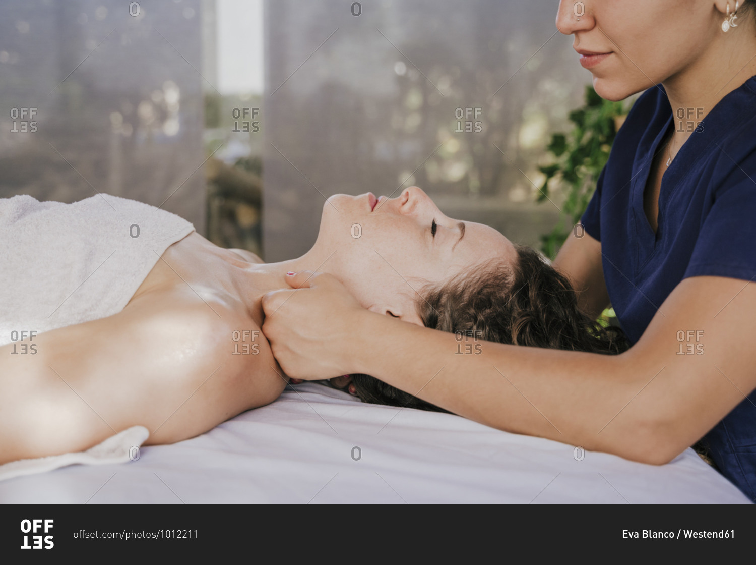 Close-up of female therapist massaging customer\'s neck on table in health spa
