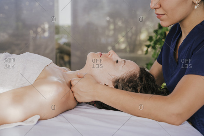 Close-up of female therapist massaging customer\'s neck on table in health spa